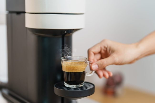 Espresso cup with steam and froth during Coffee making Coffee by