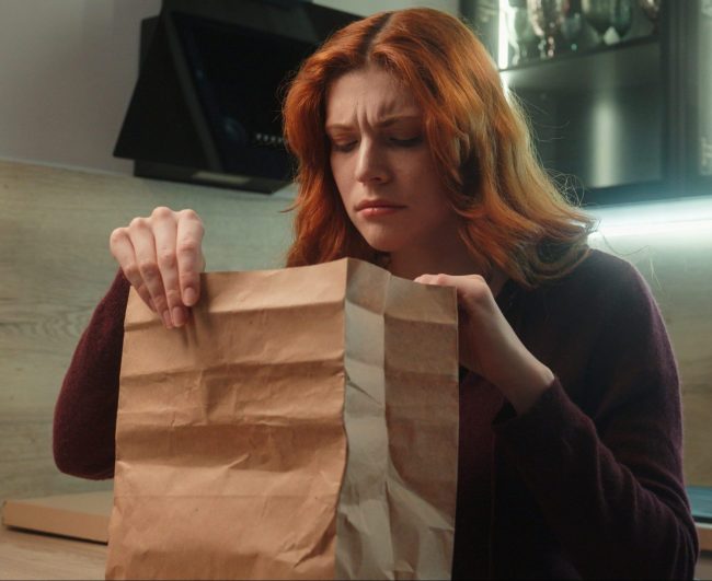 Food Delivery Packaging - woman opening delivery package concerned