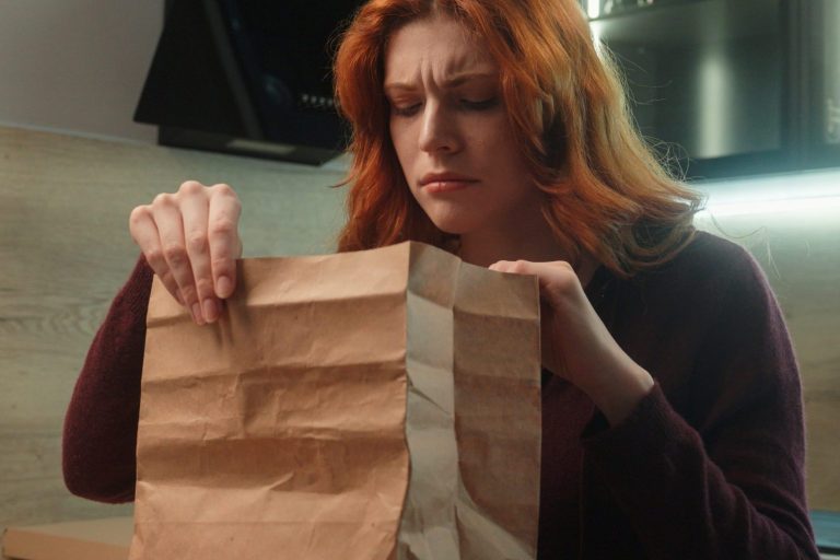 Shocked disgusted Caucasian hungry woman female client girl customer unpacking open paper bag order package sniff spoiled stink order bad smelling dish dislike smell feel nausea disgust indoor kitchen Food Delivery Packaging - woman opening delivery package concerned