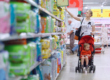 A mother and child shopping in a supermarket aisle, illustrating the practical effects and benefits of the new PPWR on product packaging for consumers.