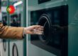 A consumer using a reverse vending machine (RVM) as part of the DRS Portugal "Volta" launch to recycle a plastic PET bottle.