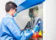 A researcher working in a laboratory safety cabinet, illustrating the NTU Singapore research behind the DIPS solvent-free method for mixed plastic packaging recycling.