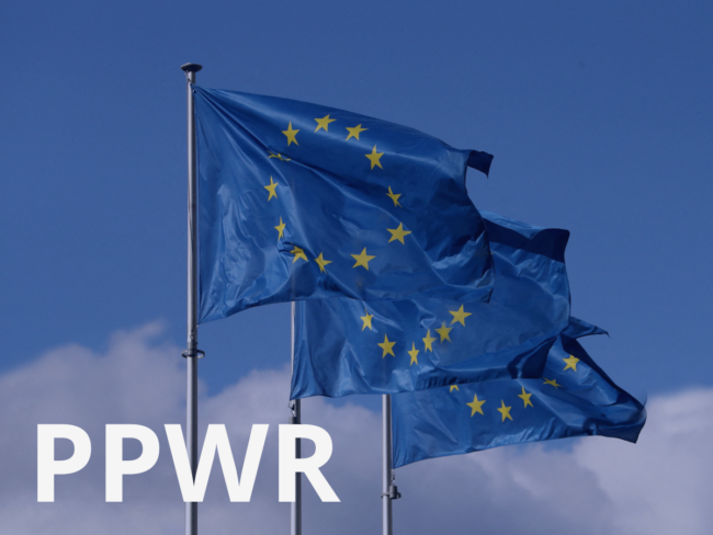 EU flags against a blue sky with "PPWR" text overlay, illustrating the industry coalition urging the EU Commission not to reopen the PPWR revision ahead of its August 2026 application date.