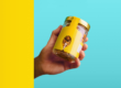 Hand holding a packaged food product with a branded label, illustrating how private label operators are classified as manufacturers under the PPWR.