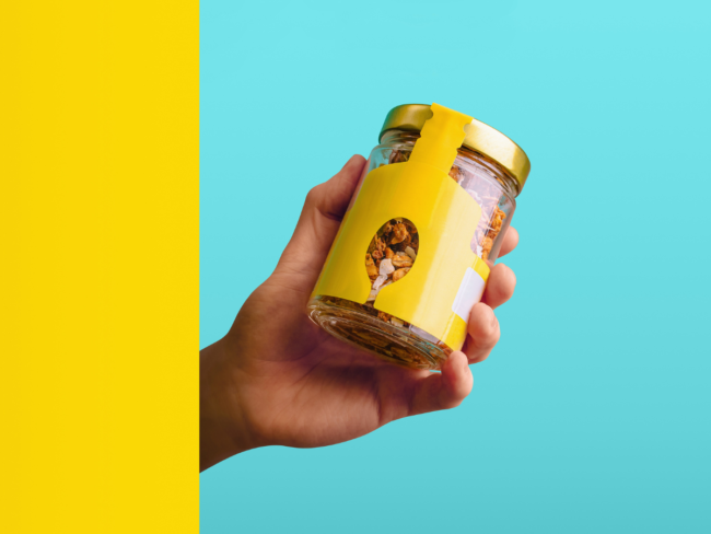 Hand holding a packaged food product with a branded label, illustrating how private label operators are classified as manufacturers under the PPWR.