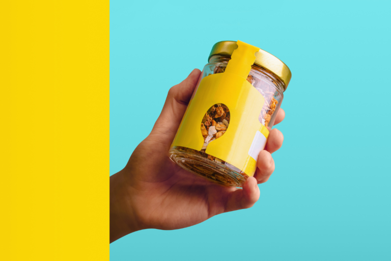 Hand holding a packaged food product with a branded label, illustrating how private label operators are classified as manufacturers under the PPWR.